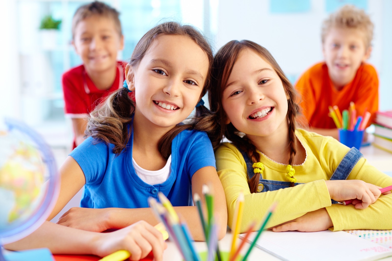 Happy students smiling at their desks